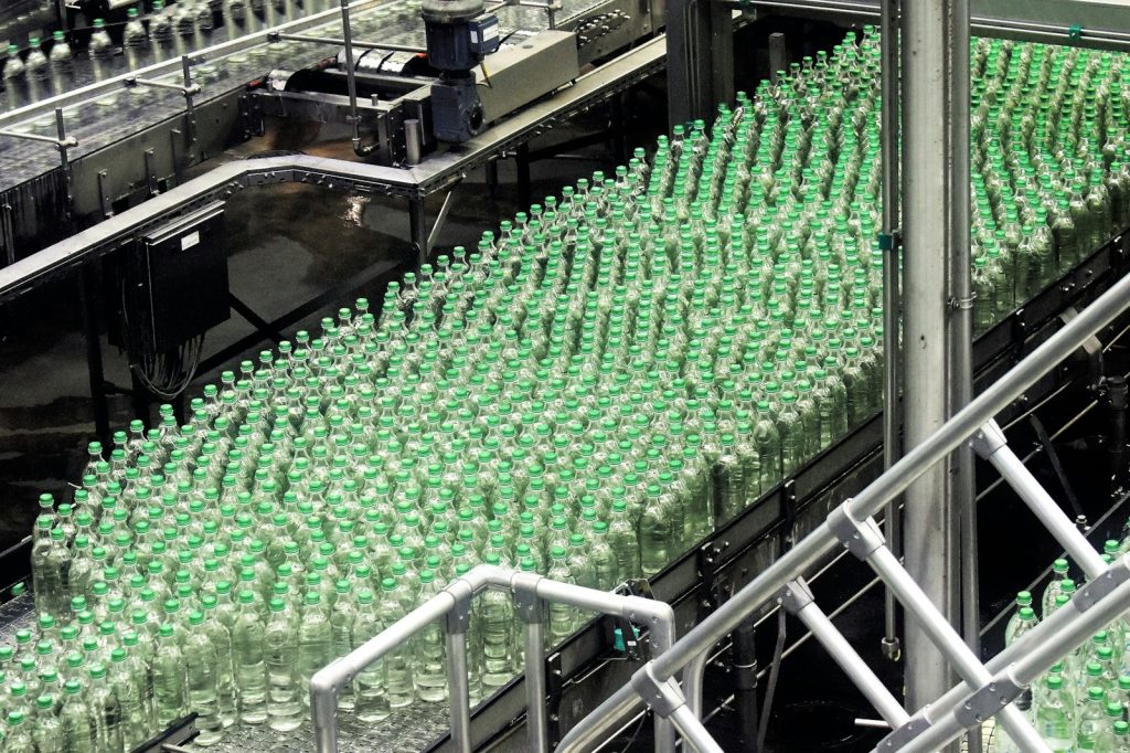 Garrafas de bebidas organizadas em uma linha de operação.